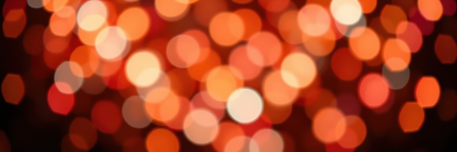 Bright orange and white bokeh lights create a festive atmosphere during a celebration in the evening